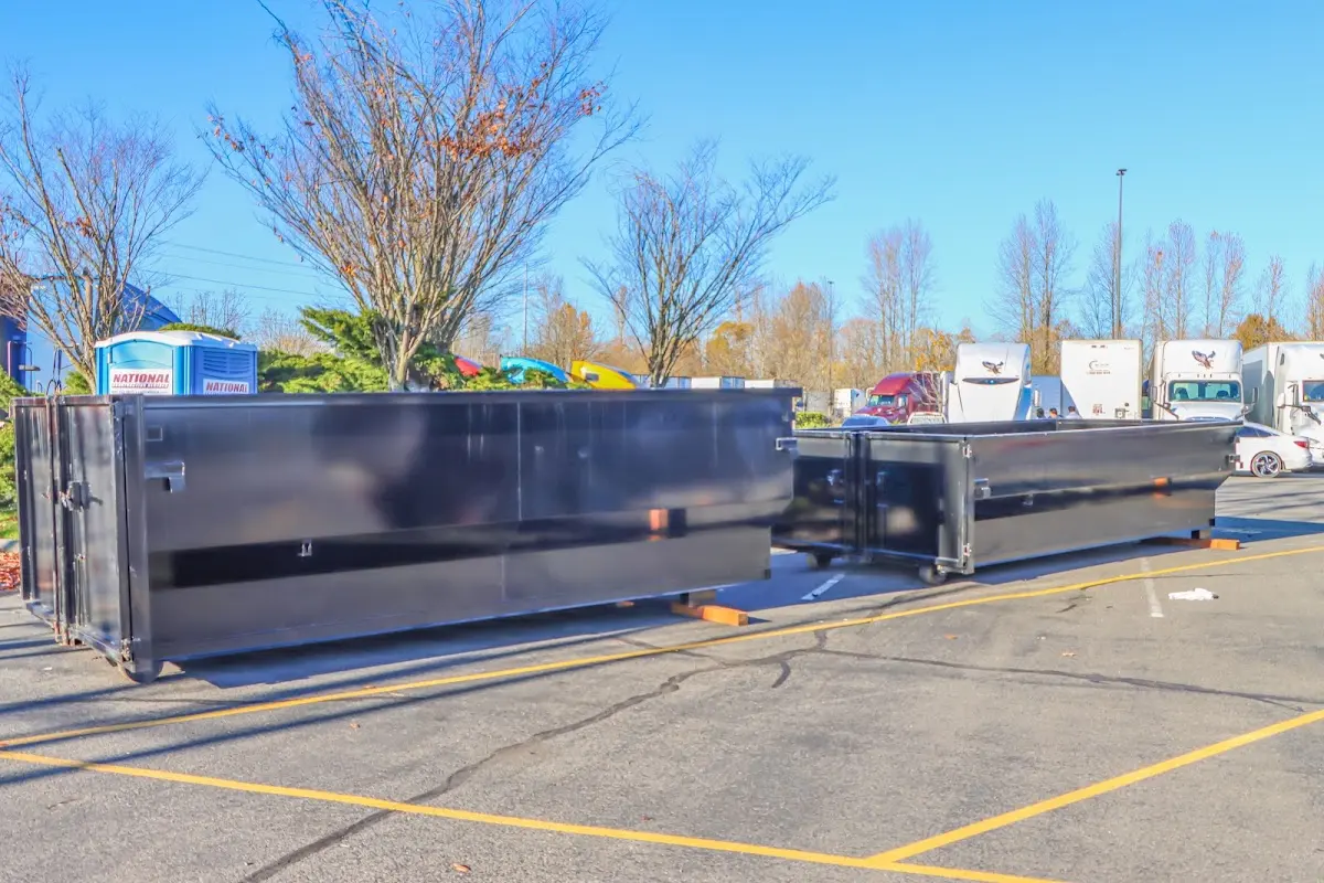 Professional dumpster rental service with roll-off container on residential driveway in Penitas